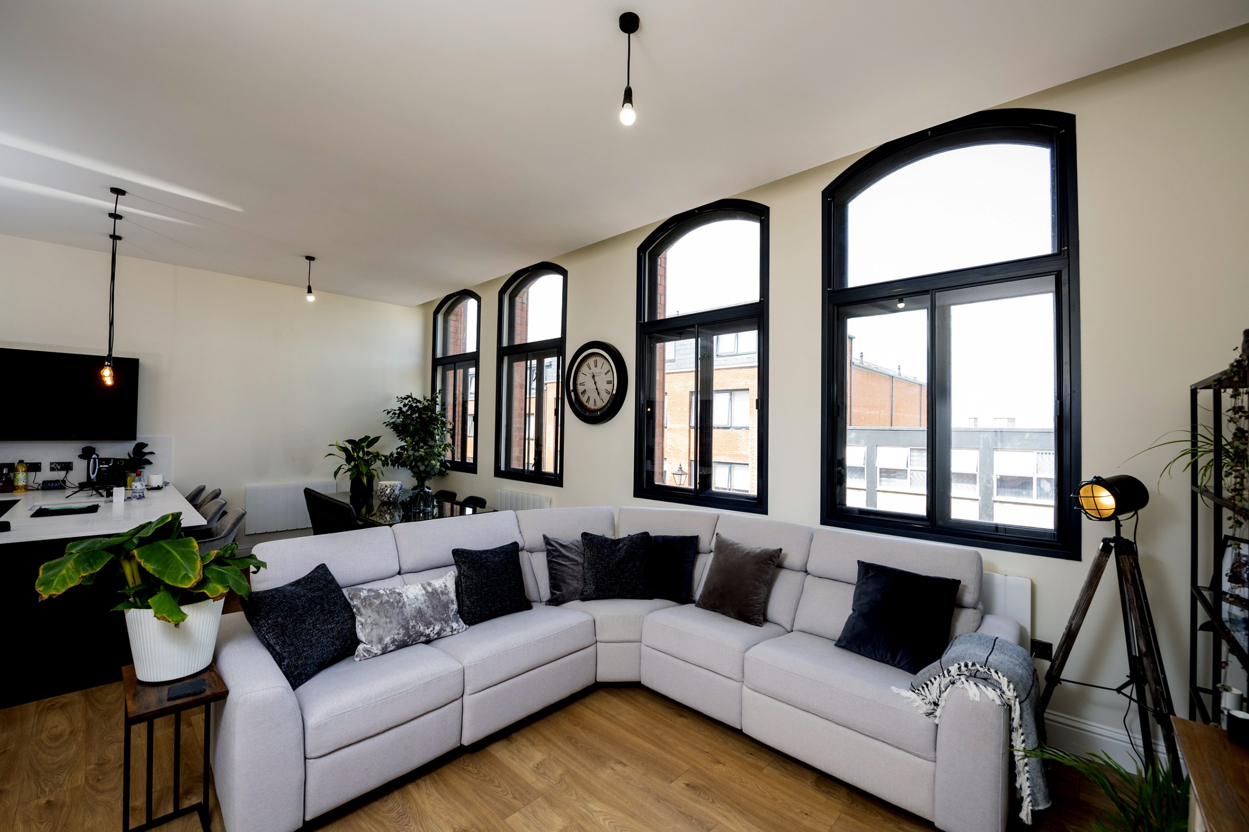 A living room with a couch, coffee table and windows.